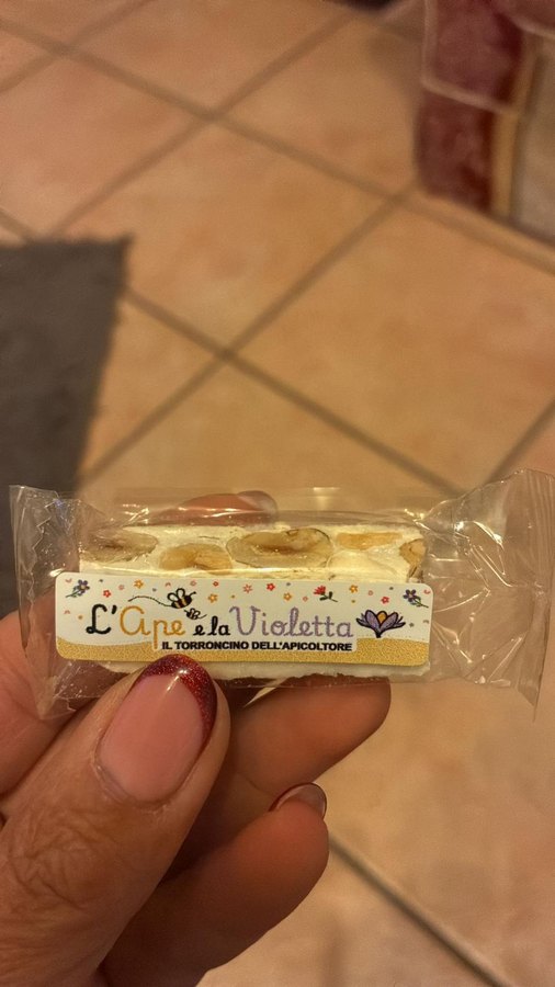 Un Torroncino dell'Apicoltore incartato singolarmente con l'etichetta L'Ape e la Violetta